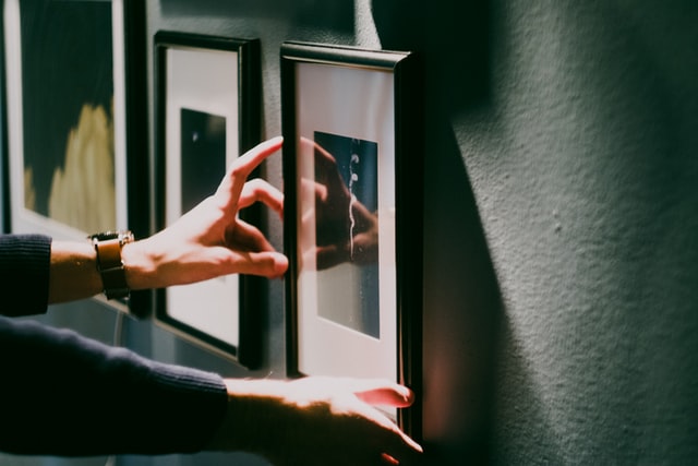 a person hanging art using the art rail system