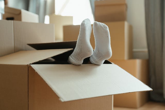 Pair of feet poking from a moving box