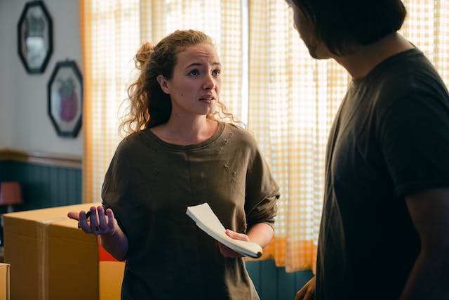 Woman holding papers and arguing with a man 