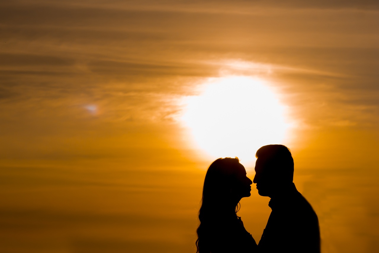 a couple on Valentine's Day with a sunset behind them